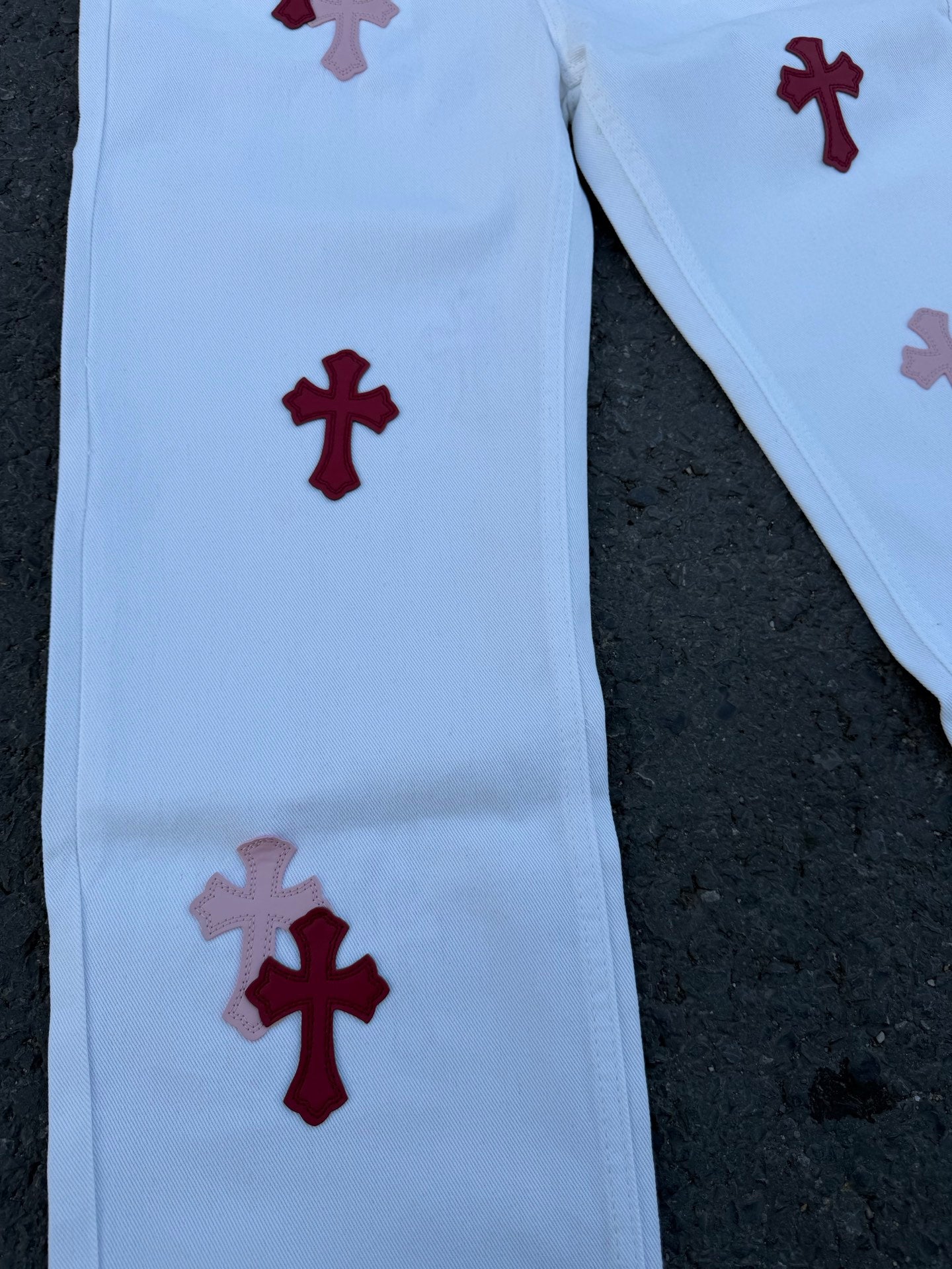 Light blue pants with red cross prints and one gray cross motif on leg
