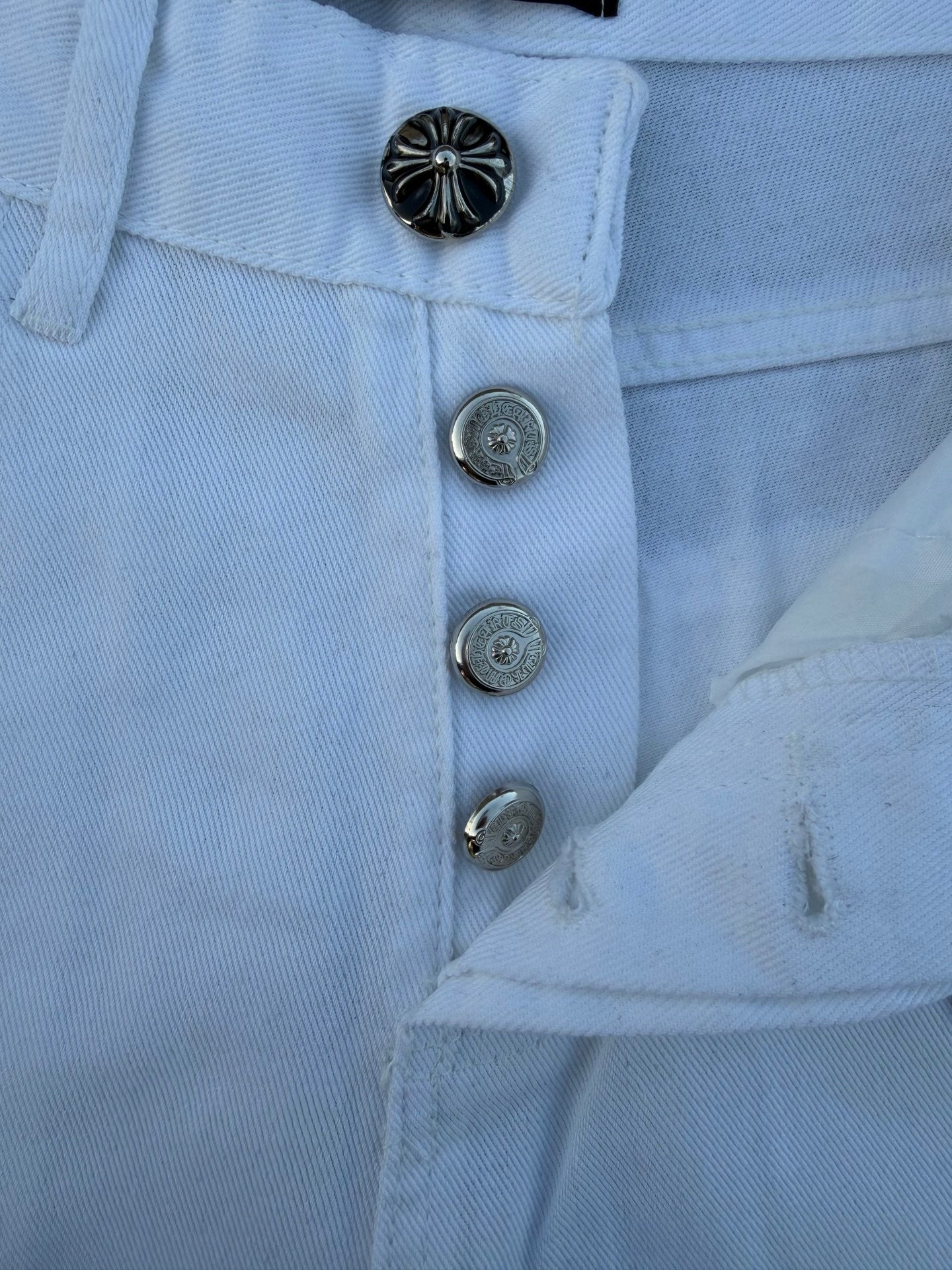 Light blue pants close-up of metal button fly and front pocket area