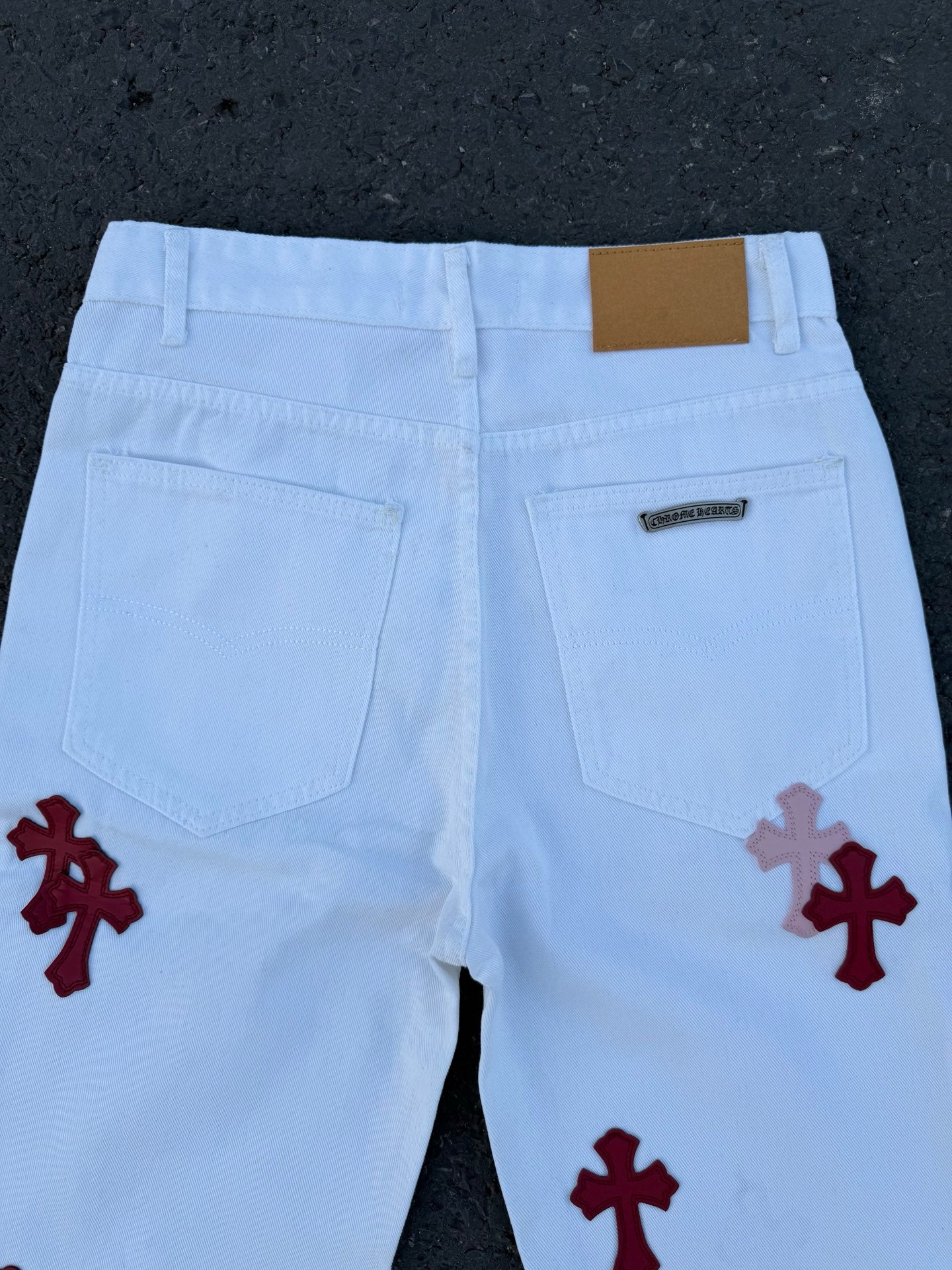 Light blue pants with red cross prints on lower front, pockets and belt loops visible