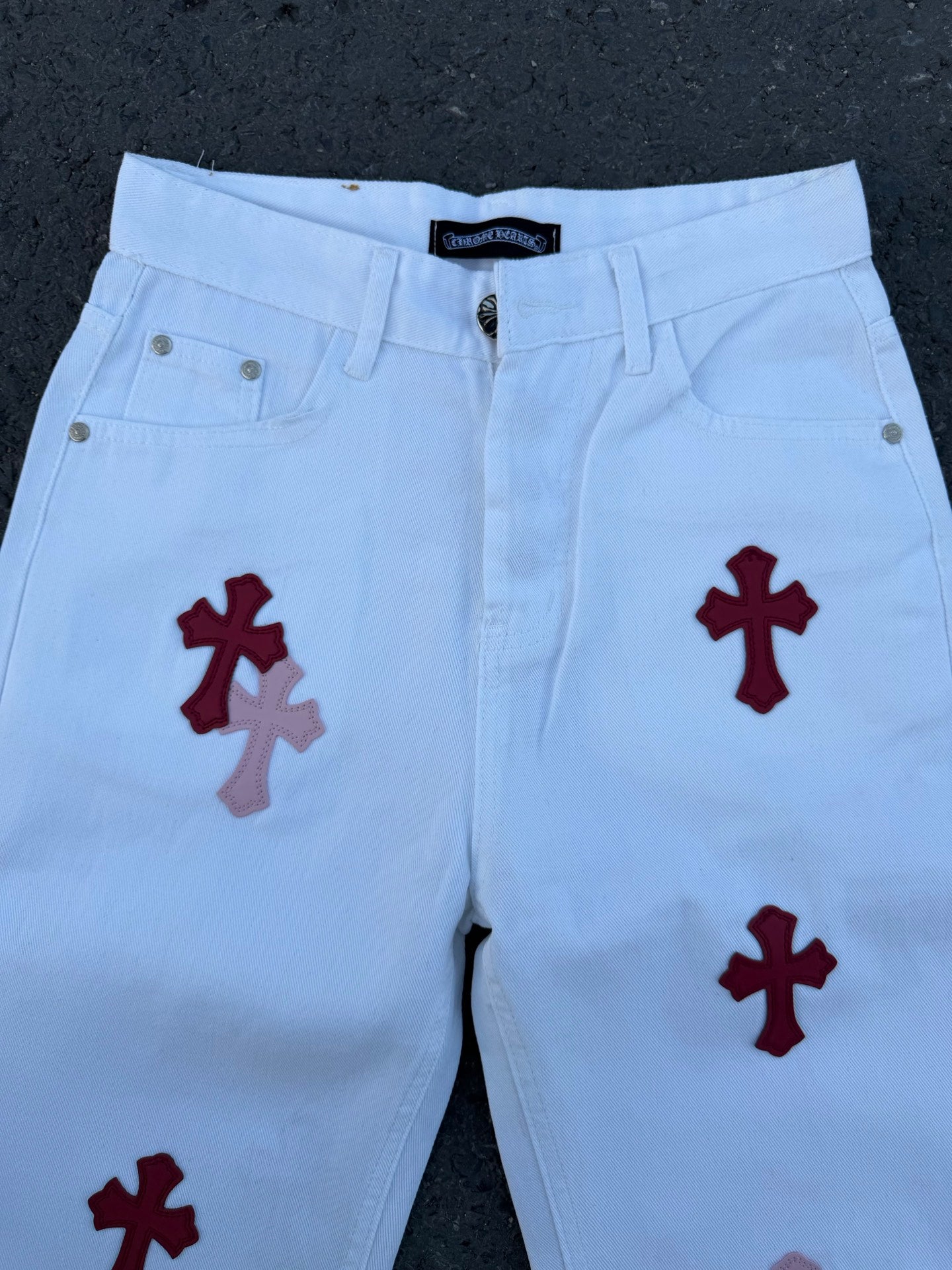 Light blue pants with red cross prints, waistband and front pockets visible