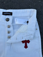 Light blue pants close-up with buttons, belt loops, and red cross graphic