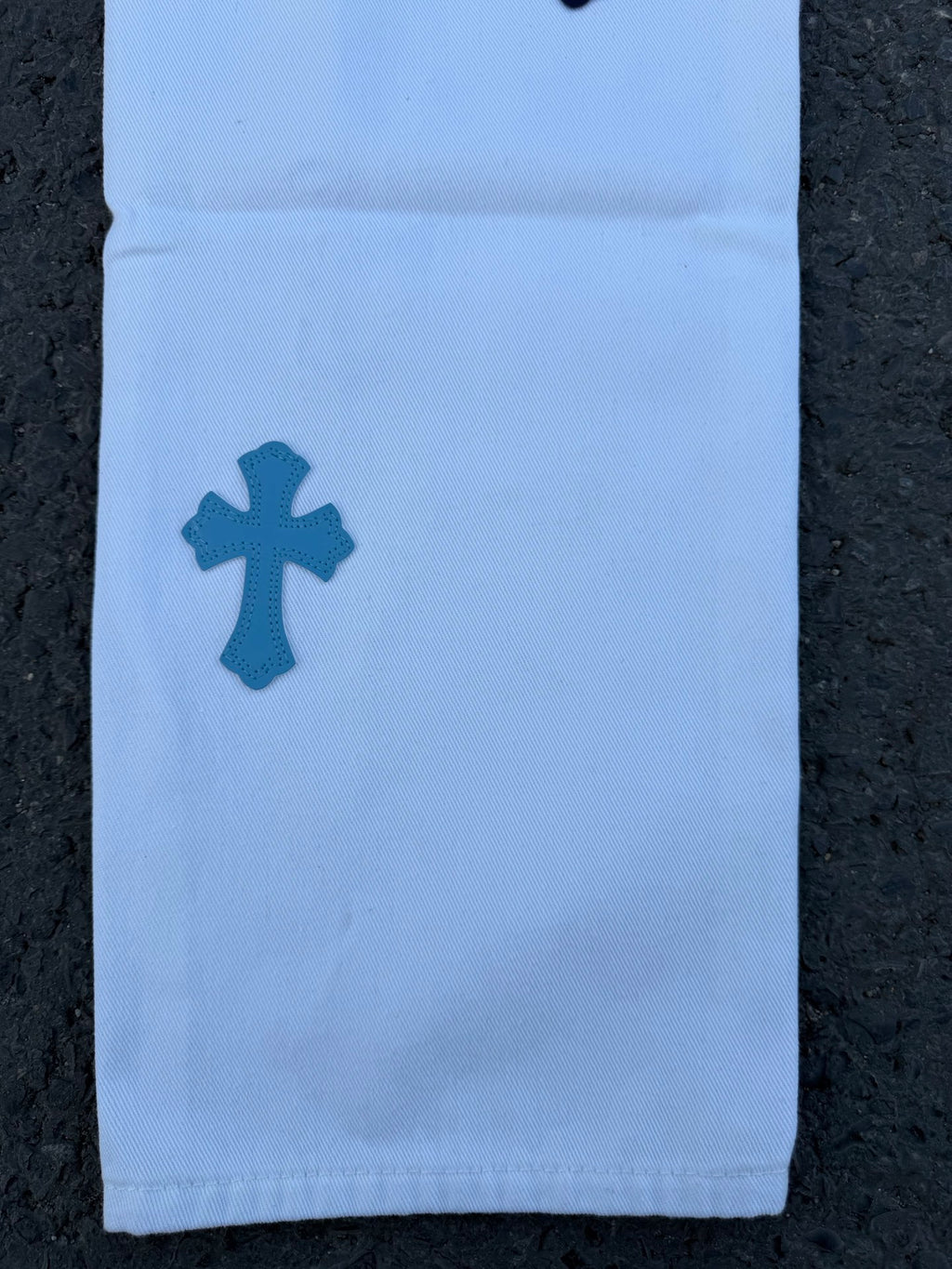 Light blue pants with dark blue cross motif on front of leg