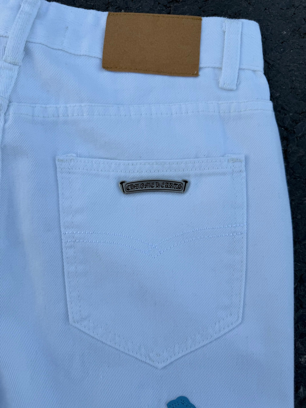 Light blue pants with navy cross print, back pocket label close-up