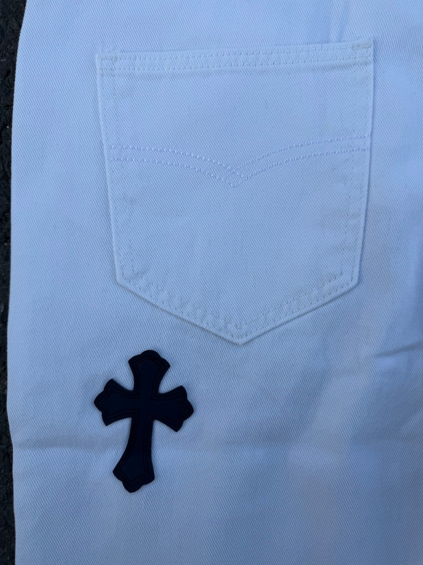 Light blue pants with navy cross print, back pocket close-up