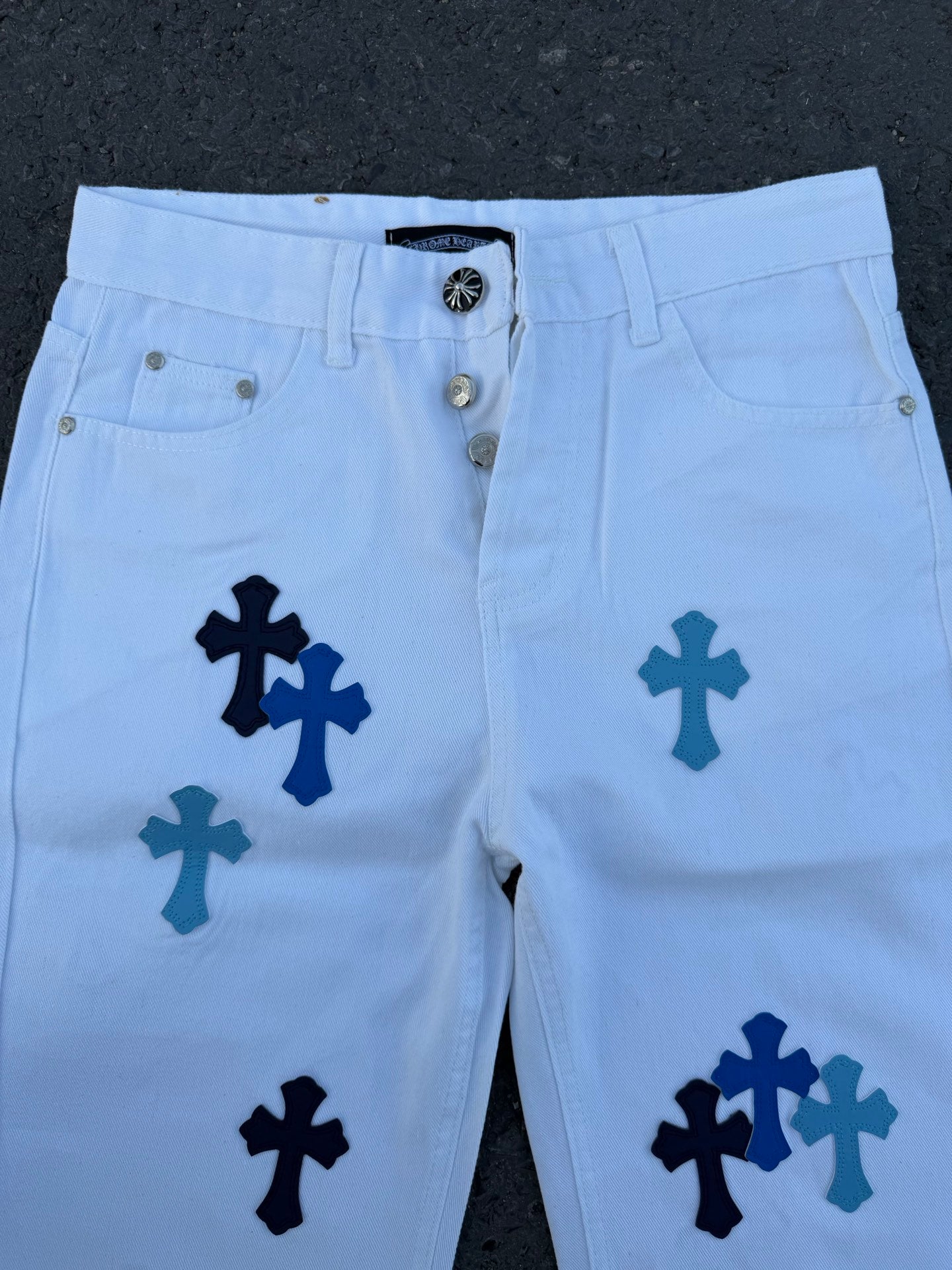 Light blue pants with navy cross print, close-up of front