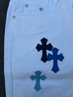 Light blue pants with navy cross applique print, front close-up