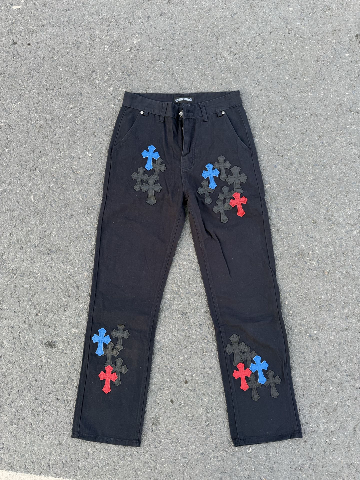 Dark gray pants with drawstring waistband and colorful cross patches on legs