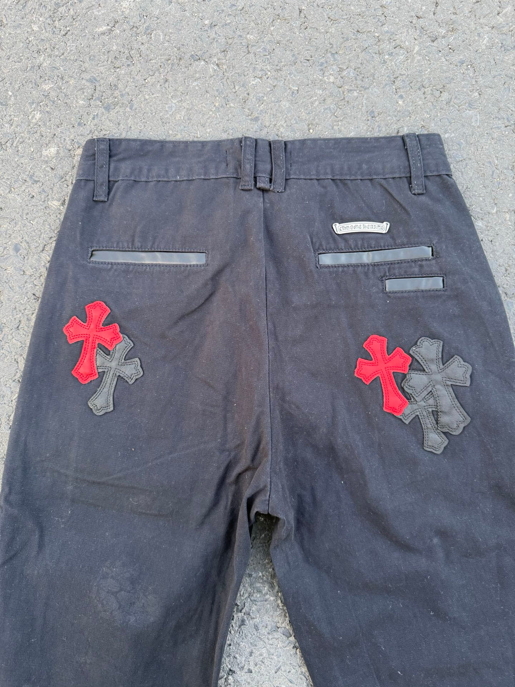 Dark gray pants with front flat waistband and colorful cross patches on each leg