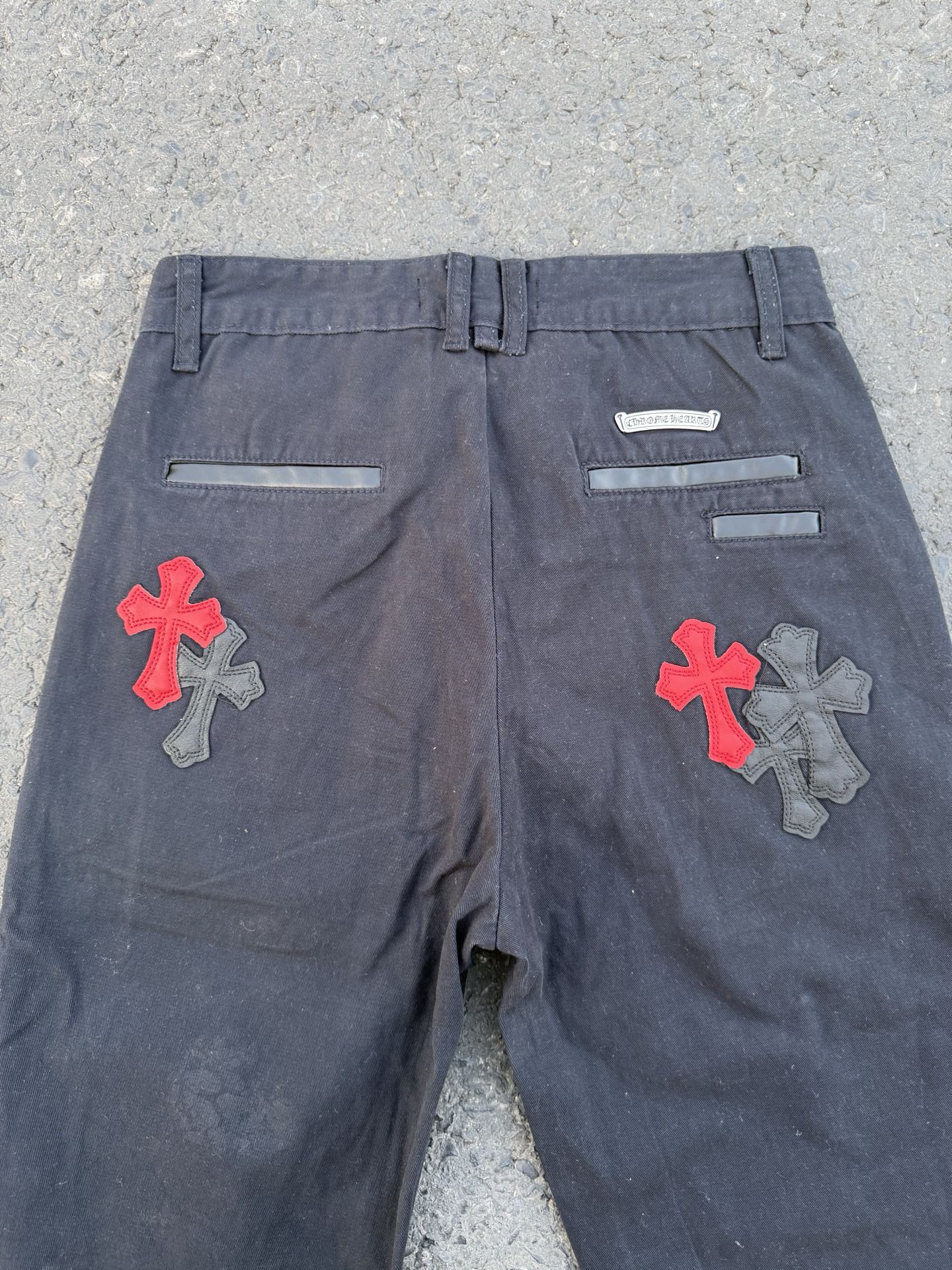 Dark gray pants with front flat waistband and colorful cross patches on each leg