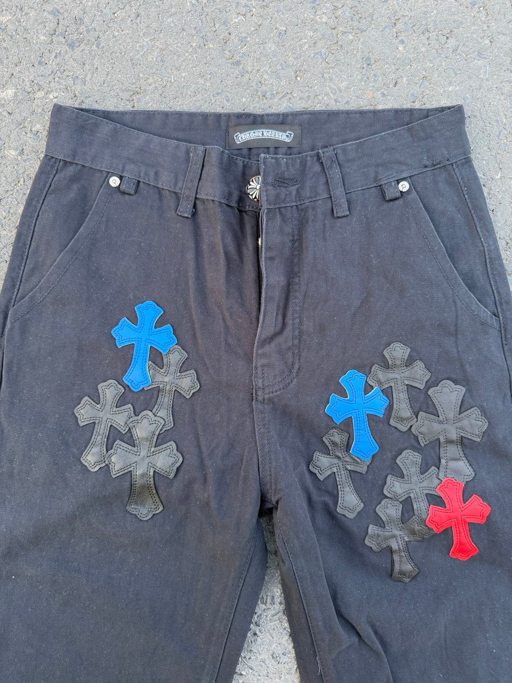 Dark gray pants with front fly and large blue, gray, and red cross patches