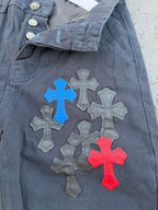 Dark gray pants close-up with belt loop and colorful cross applique on knee