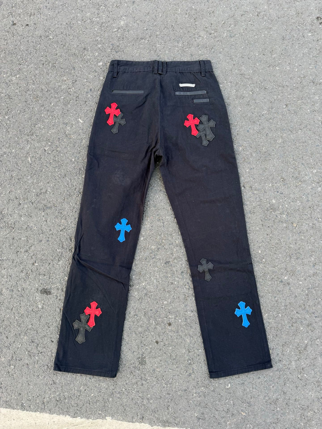 Dark gray straight-leg pants with colorful cross patches and back pocket details