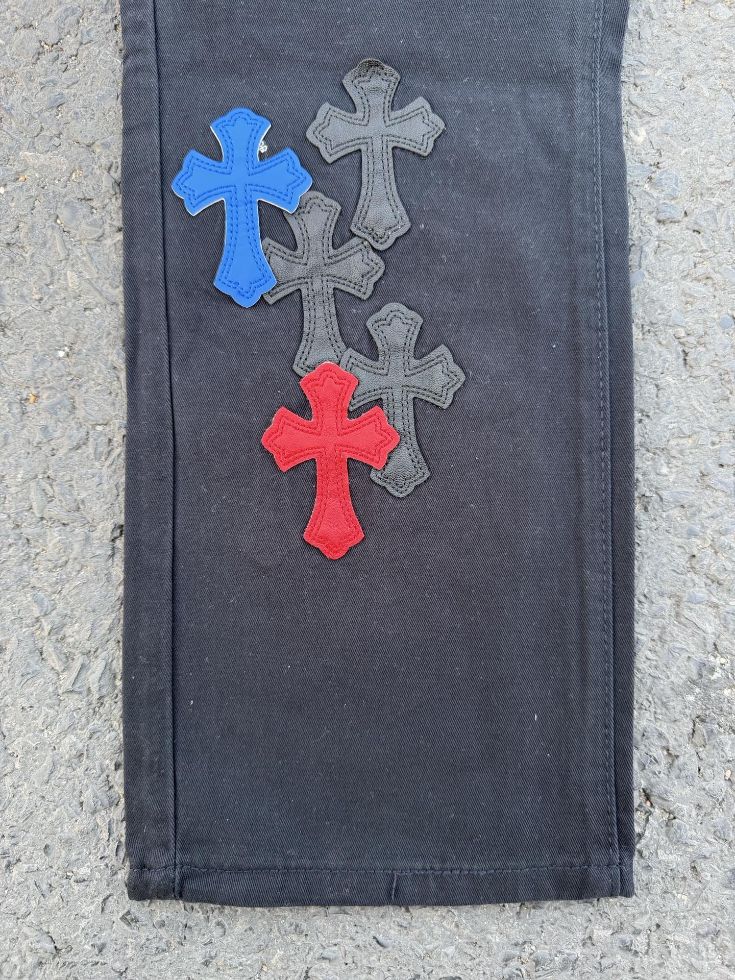 Denim pants with blue, gray, and red cross patches, straight leg