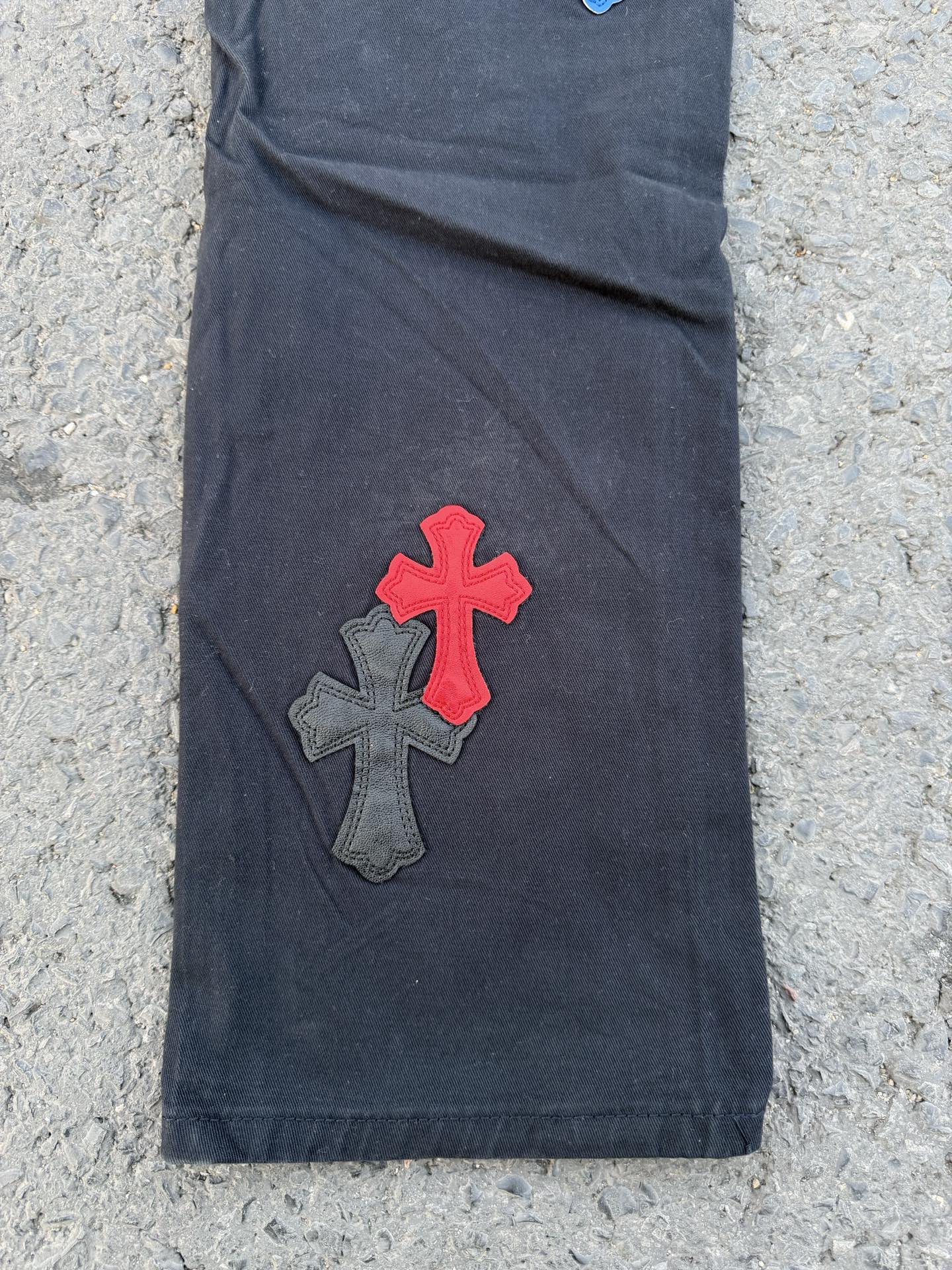 Denim pants with red and gray cross appliques on front