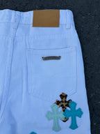 Light blue pants back panel with patch label and cross applique near pocket