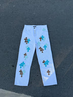 Light blue pants with green and black cross appliques all over