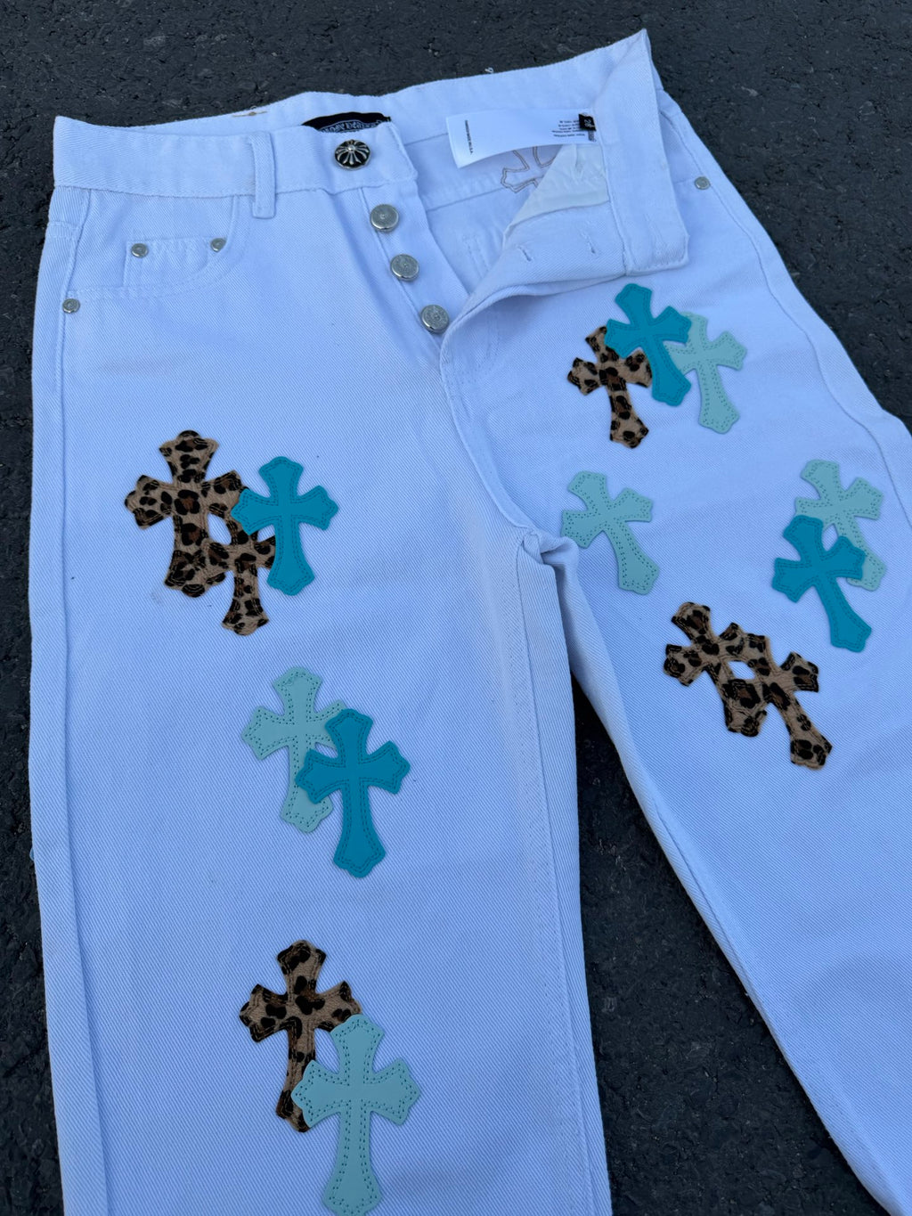 Light blue pants with cross appliques and front button closure