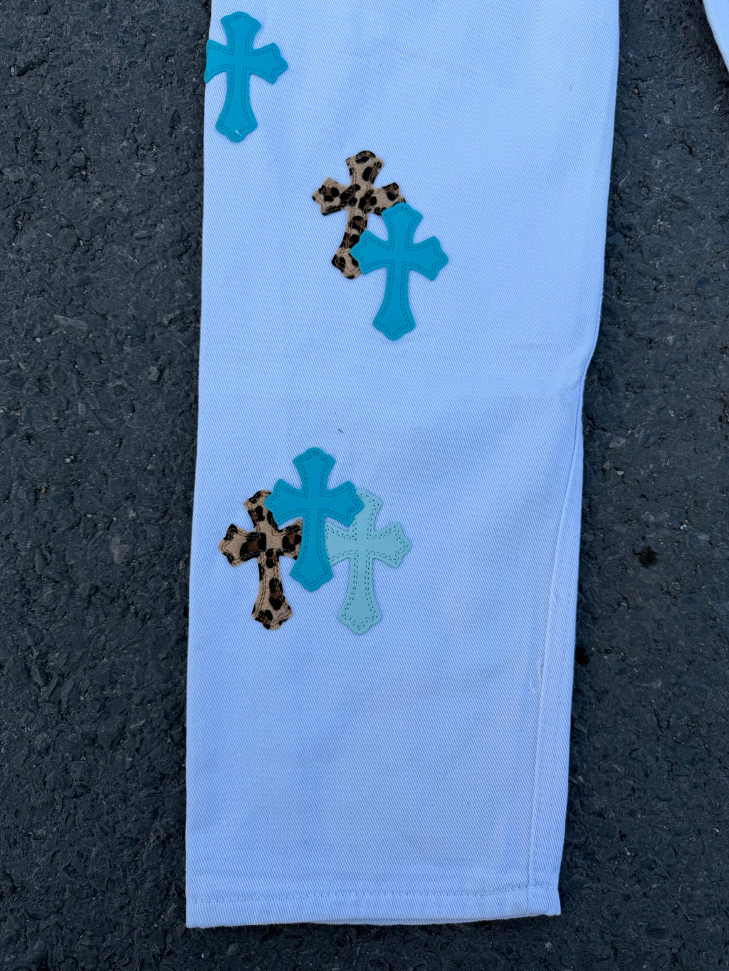 Light blue pants leg with scattered teal and dark spotted appliqué patches