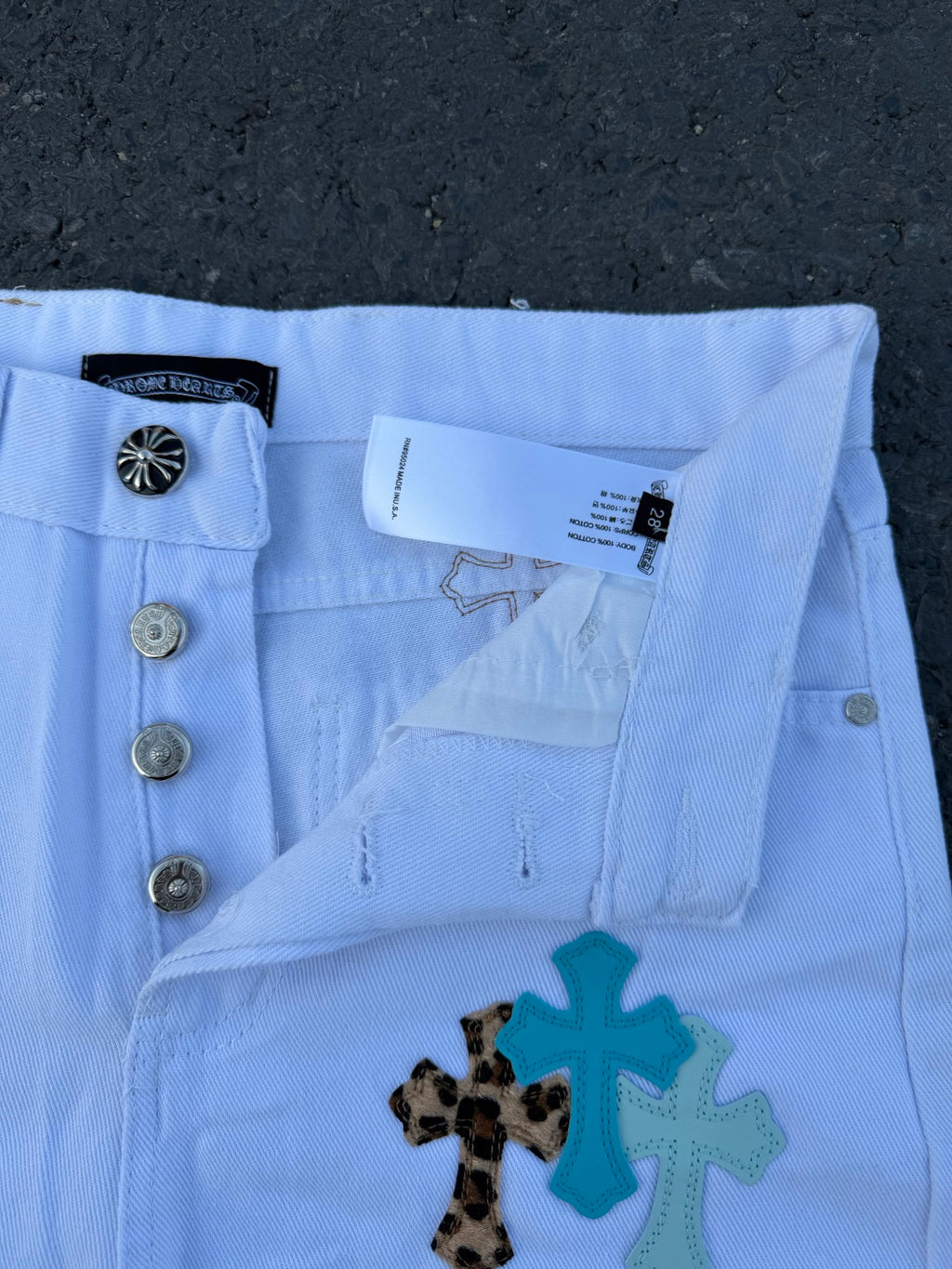 Light blue pants with side pockets and cross applique detail
