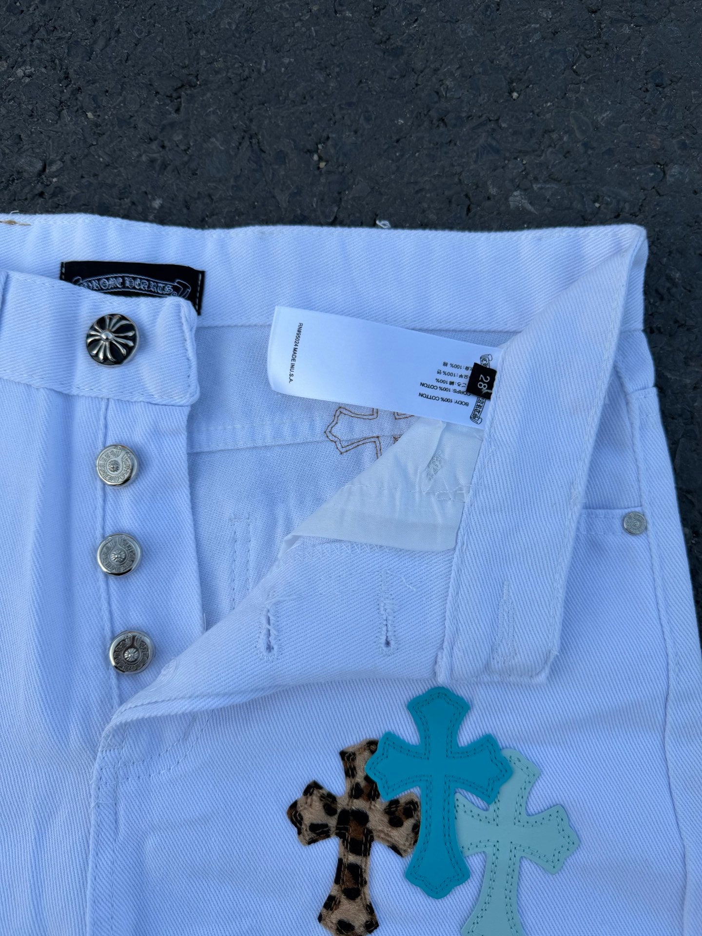 Light blue pants with side pockets and cross applique detail