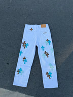 Light blue straight-leg pants with scattered cross appliques on the front