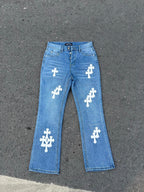 Light blue denim jeans with white cross patches, straight leg.