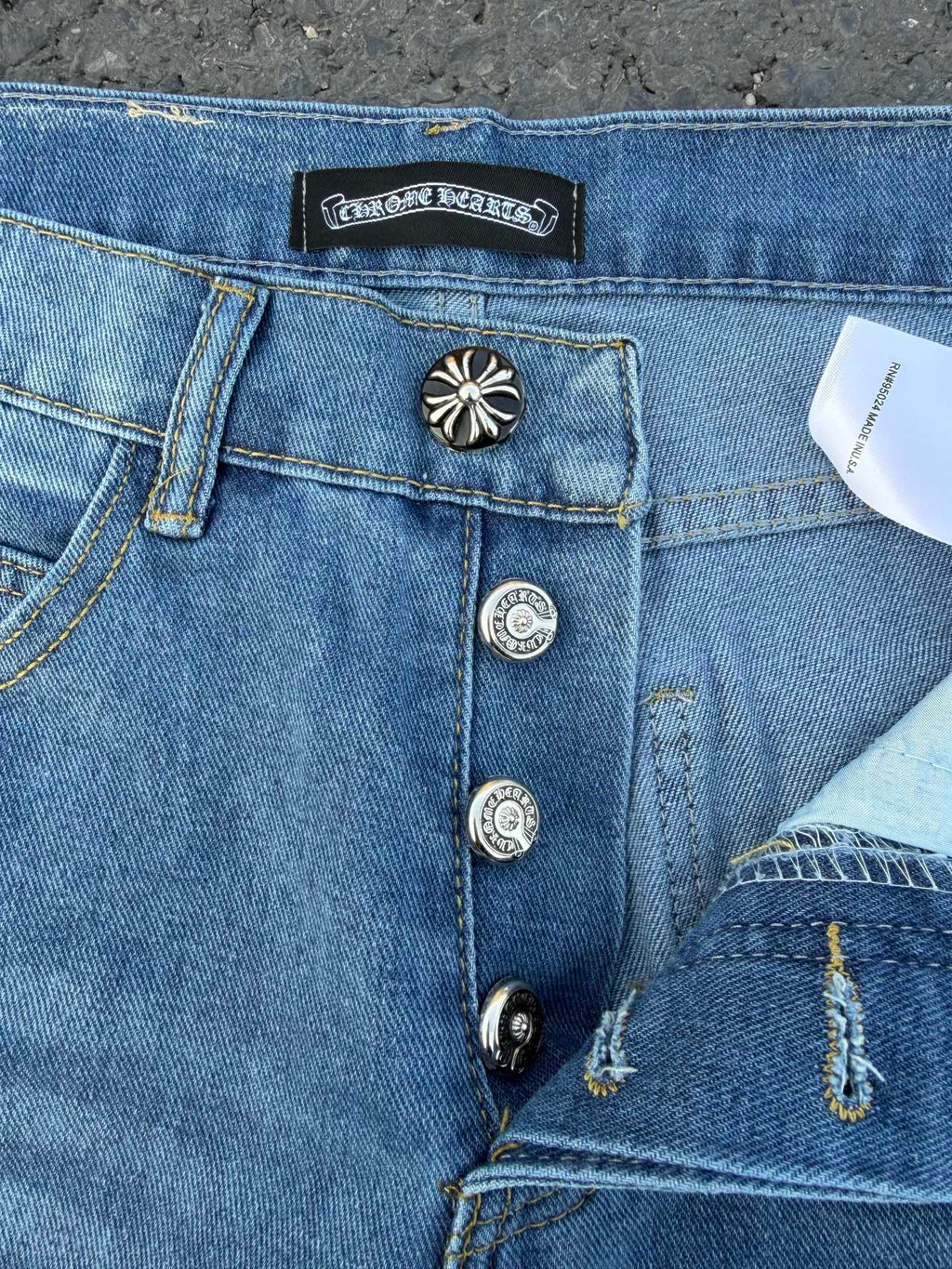 Light blue denim jeans waistband and front pocket details, button fly.