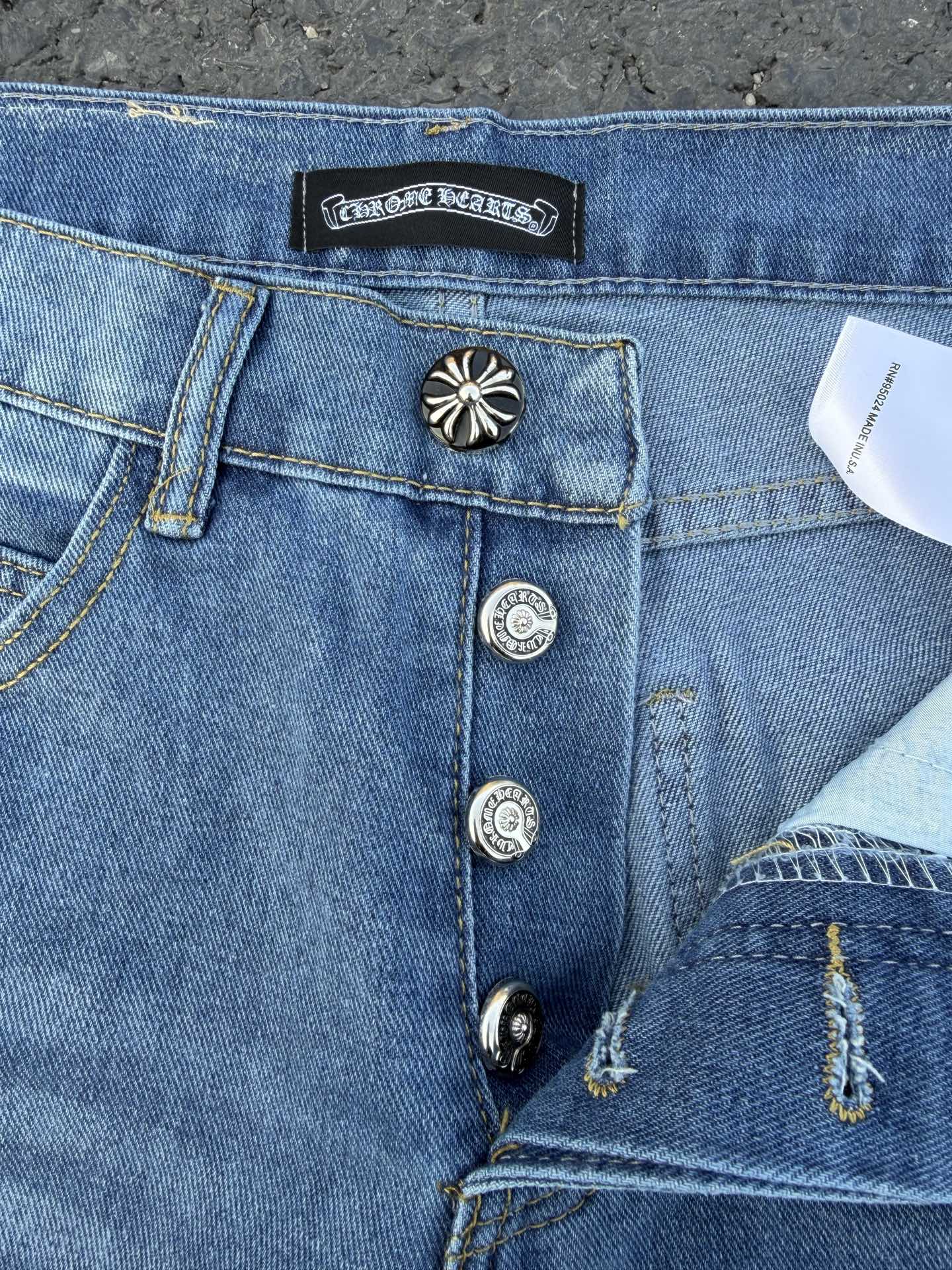 Light blue denim jeans waistband and front pocket details, button fly.