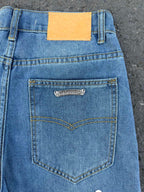 Light blue denim jeans back waistband with heart-shaped pocket, orange tag.