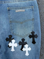 Back pocket of light blue denim pants with label and cross patches below