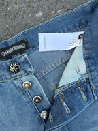 Close-up of light blue denim pants showing belt loops and fabric tag