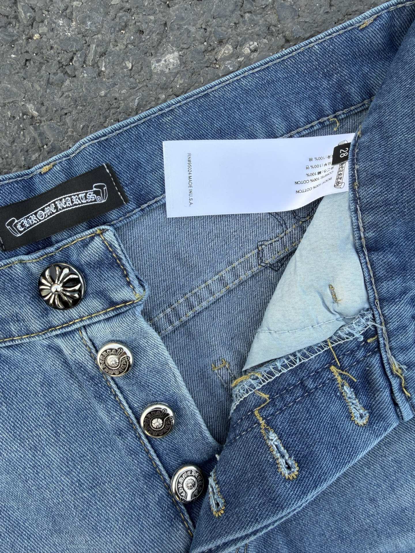 Close-up of light blue denim pants showing belt loops and fabric tag