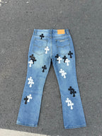 Light blue denim pants featuring scattered black and white cross patches