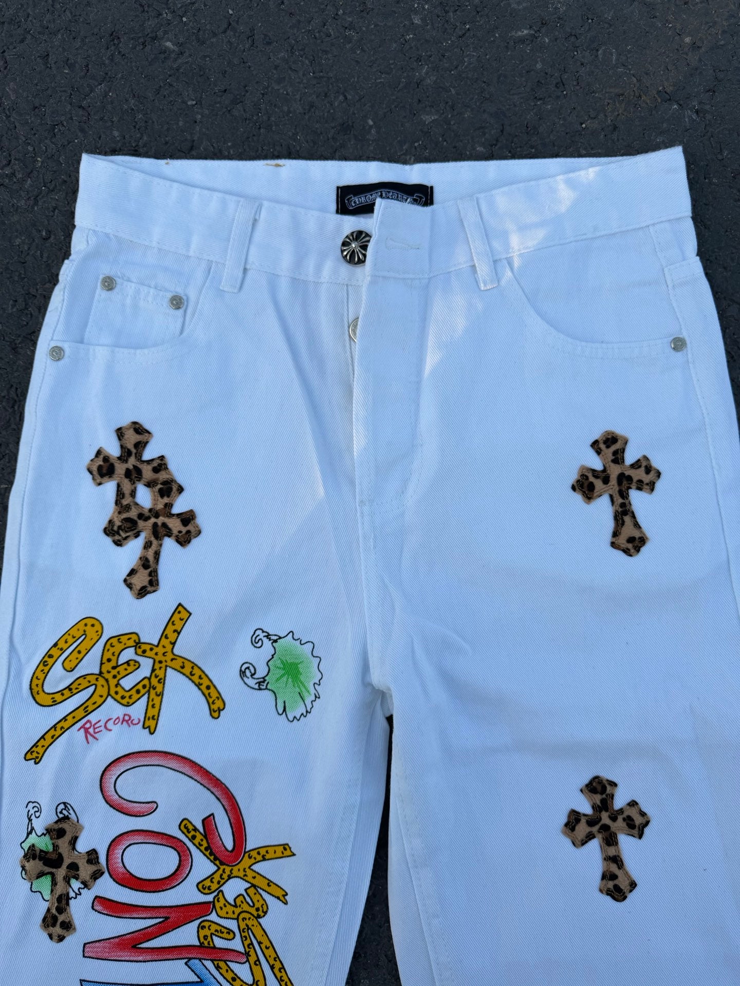 Light blue pants with dark cross patches and colorful graphic patches on front