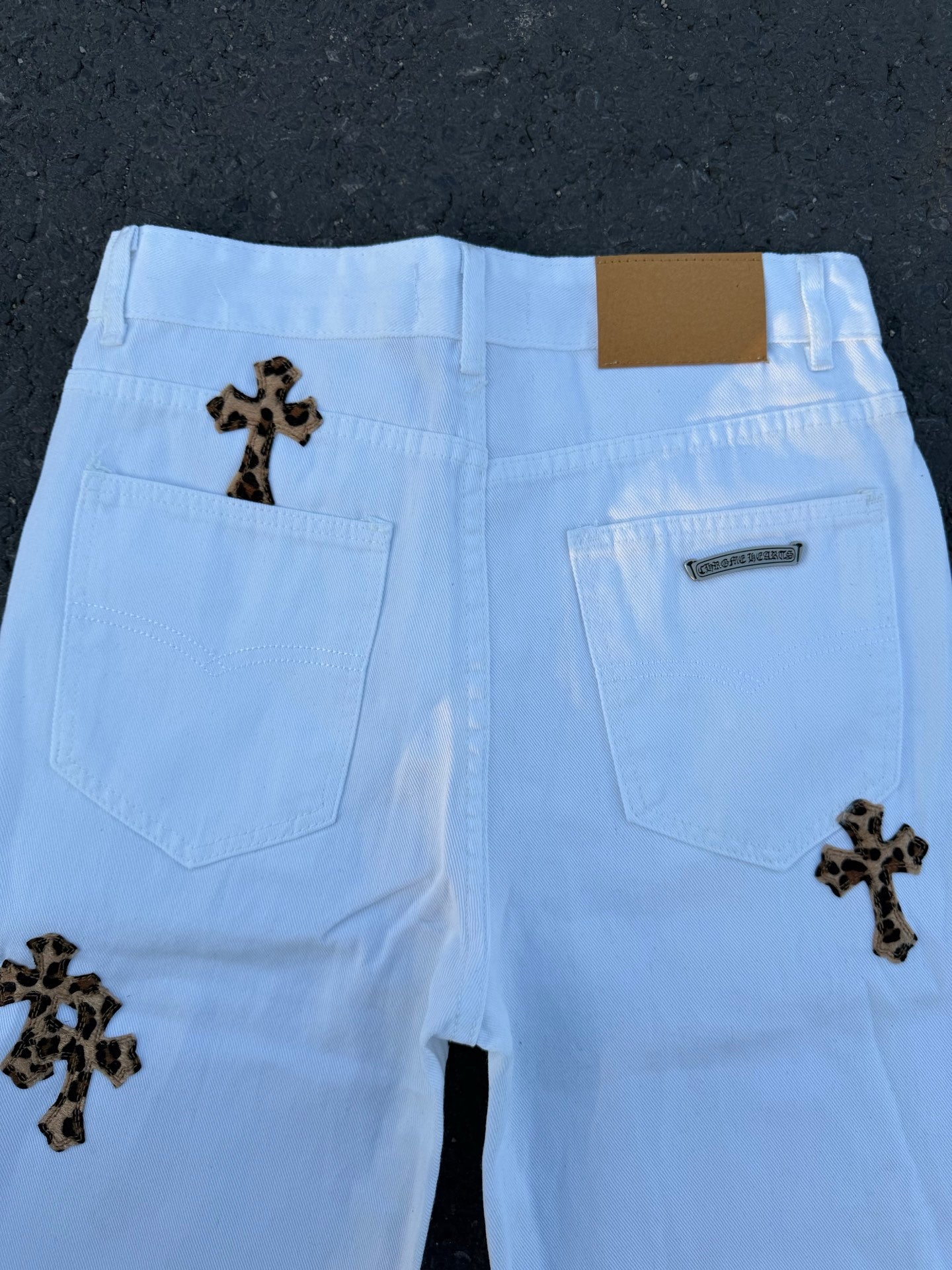 Light blue pants back view with dark cross patches and two rear pockets