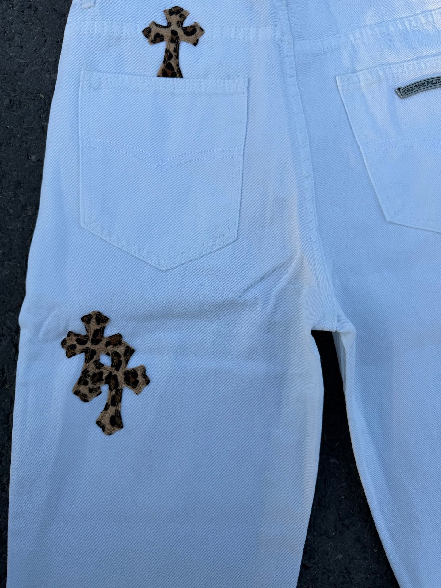 Light blue pants back view with two rear pockets and dark cross patches