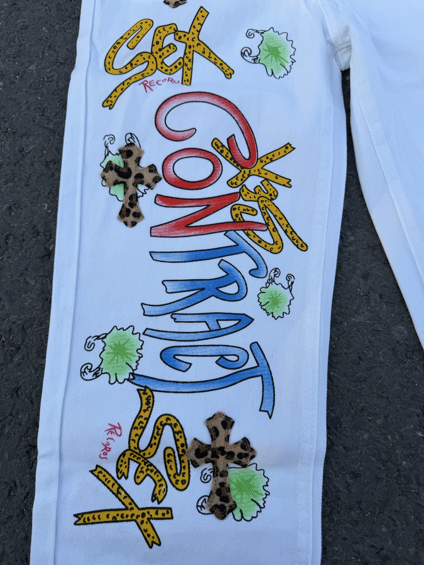 Light blue pants with large colorful graffiti-style graphic print on front