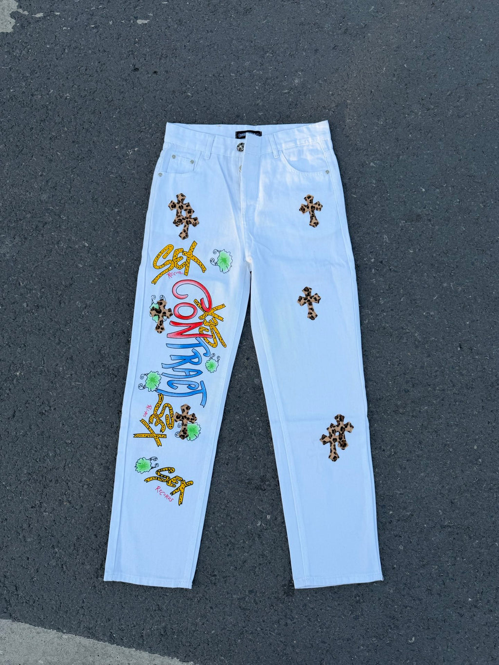 Light blue straight pants with dark cross patches, button fly and belt loops