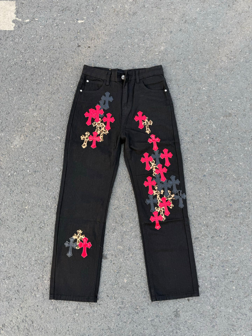 Black denim pants with colorful cross patches and elastic drawstring waistband.