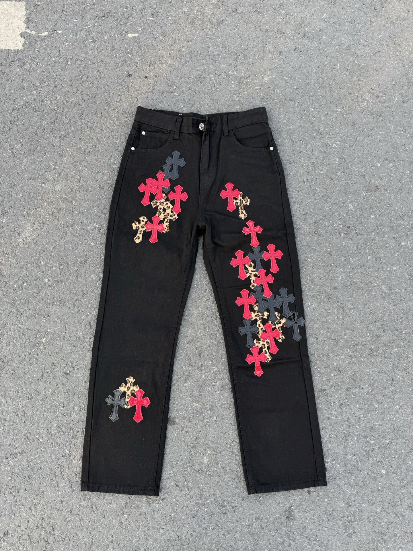 Black denim pants with colorful cross patches and elastic drawstring waistband.