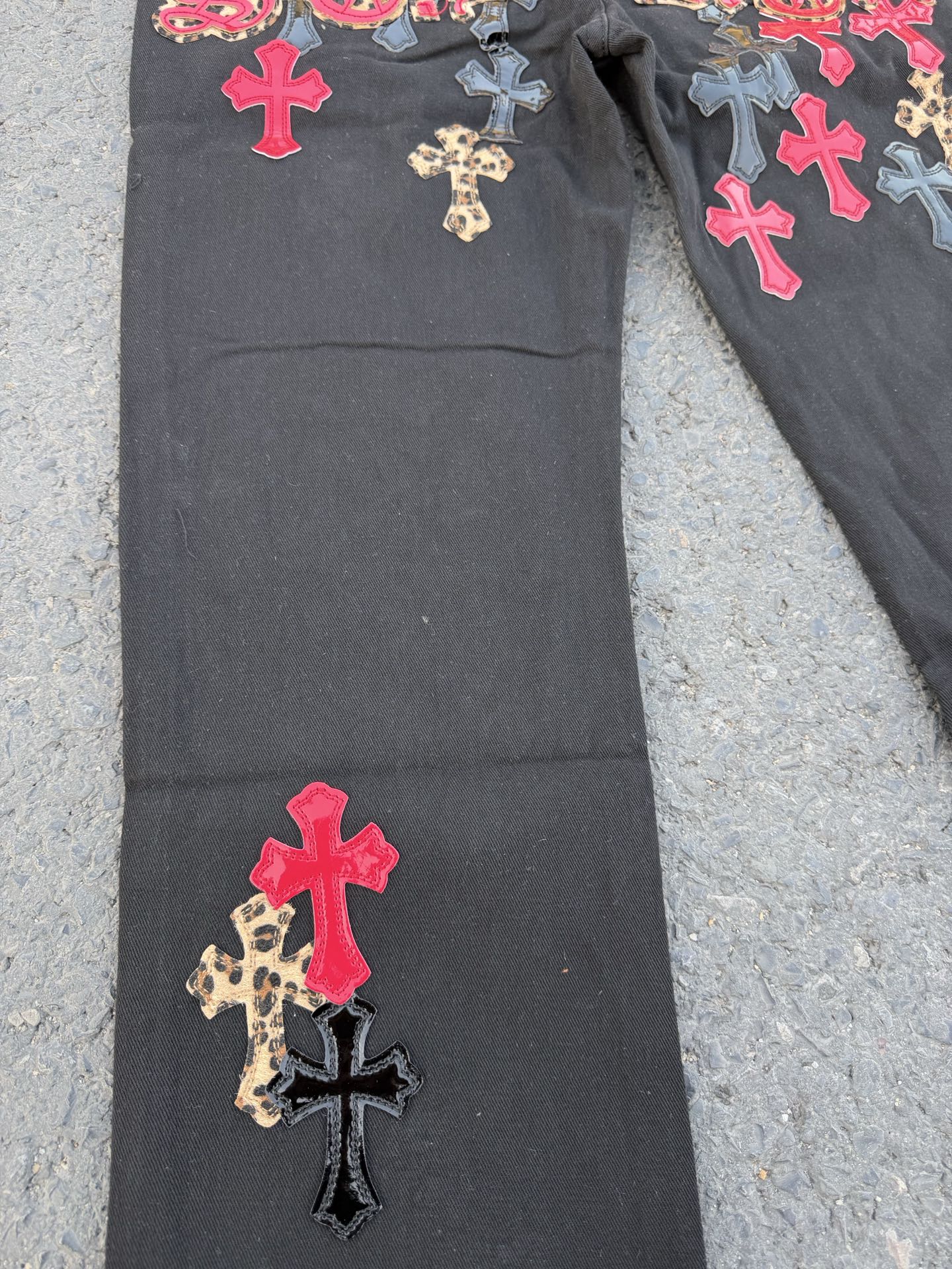 Black pants with red cross patches and small leopard print cross applique