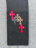 Black pants with two red cross patches and a leopard print cross applique
