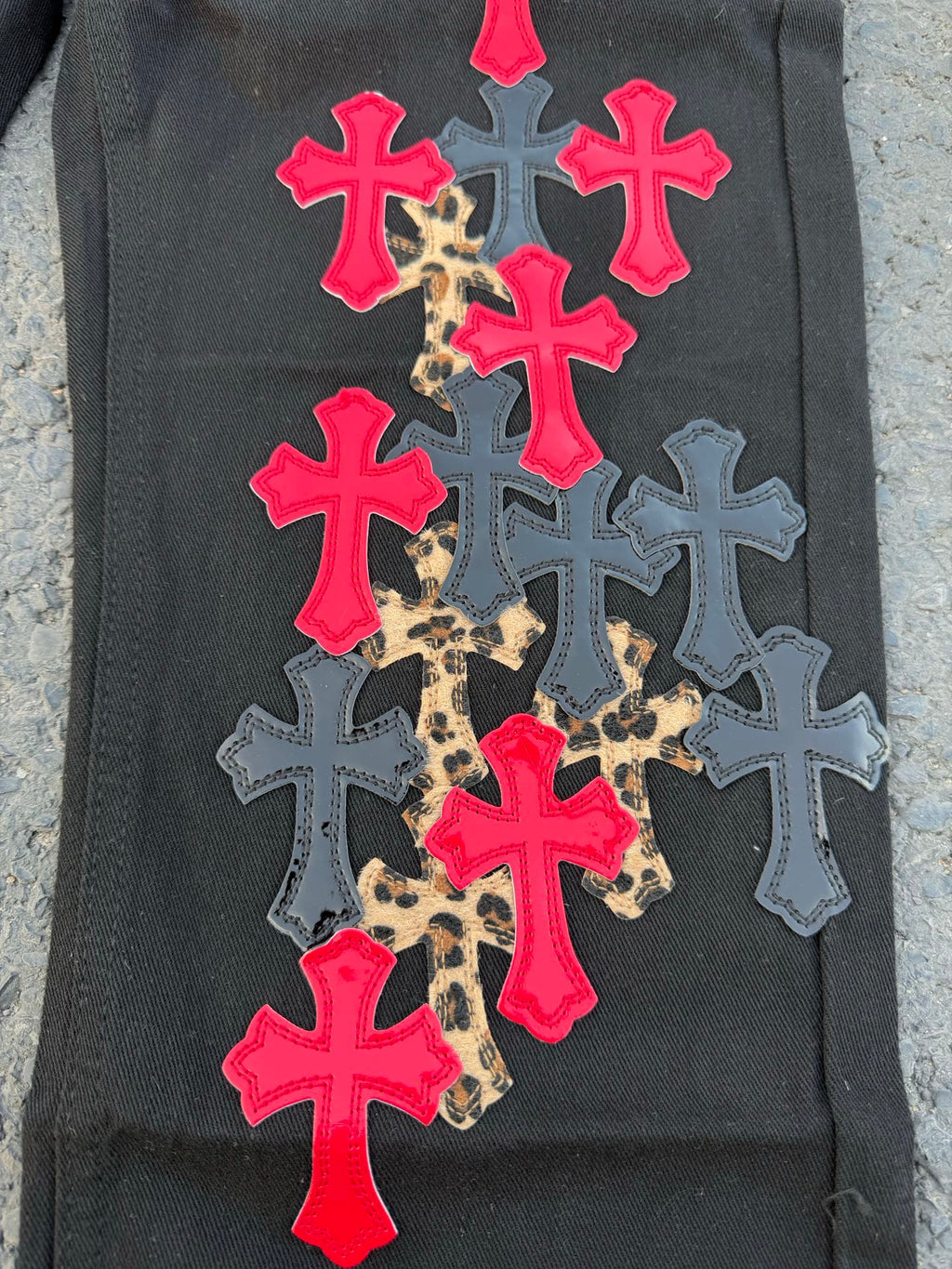 Black pants covered with colorful cross patches in red, blue, and leopard print