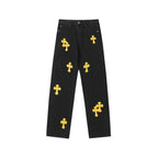 Black denim pants with scattered yellow cross patches