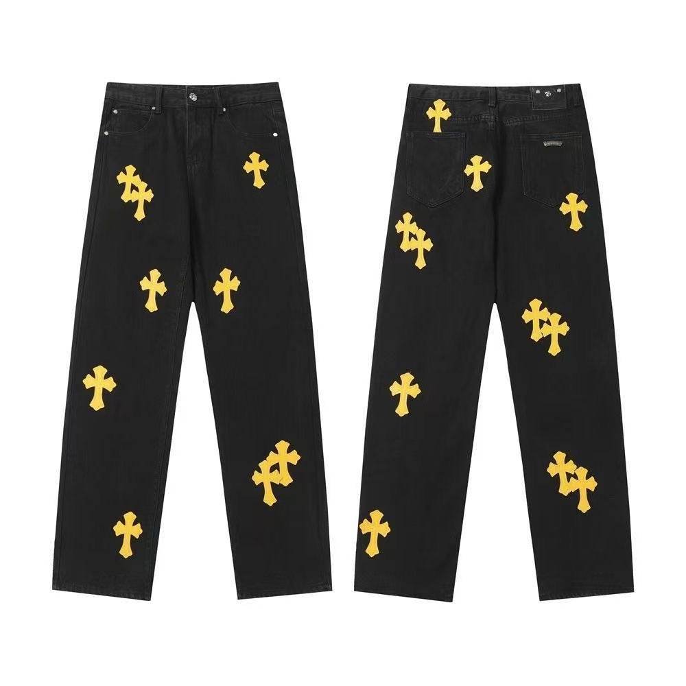 Black denim pants with scattered yellow cross patches, front and back views