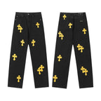 Black denim pants with scattered yellow cross patches, front and back views