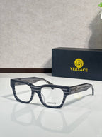 Versace eyeglasses with dark navy frame, clear lenses, and gold Medusa emblem on the temple