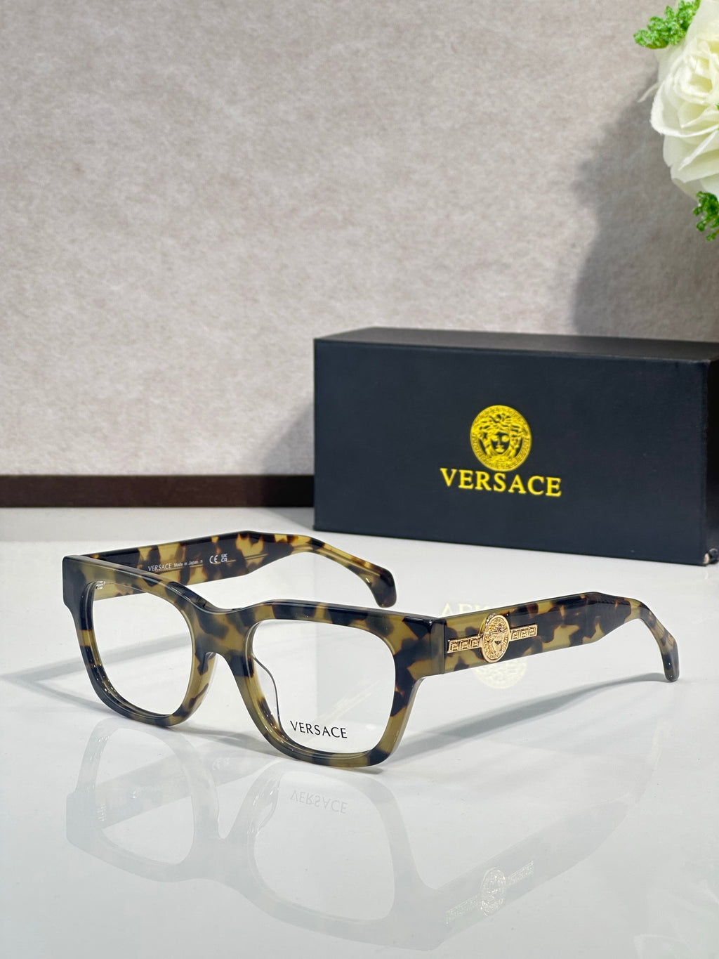 Versace eyeglasses with tortoise-pattern frame and gold Medusa emblem on the temple, clear lenses