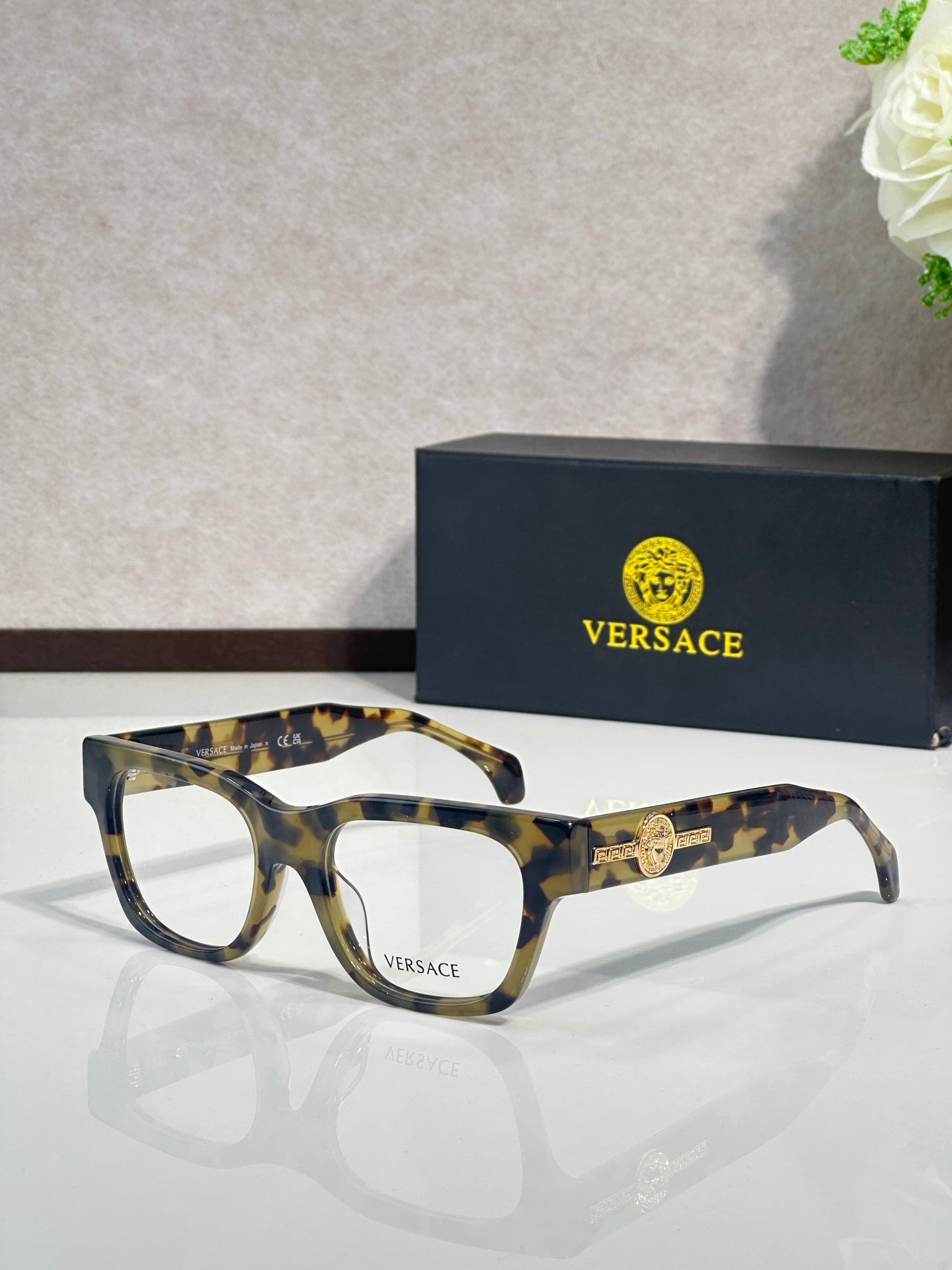Versace eyeglasses with tortoise-pattern frame and gold Medusa emblem on the temple, clear lenses