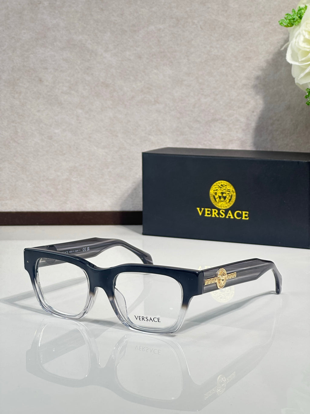 Versace eyeglasses with dark navy frame and gold Medusa emblem on the temple, clear lenses